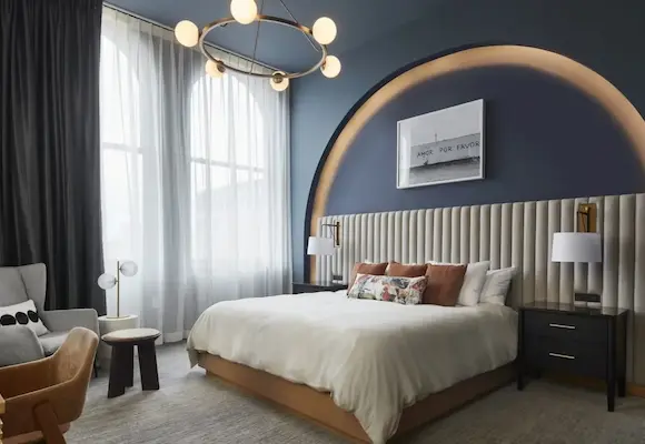 luxury King hotel room at Kinn Guesthouse featuring a large lighted arch and dark blue walls and ceiling